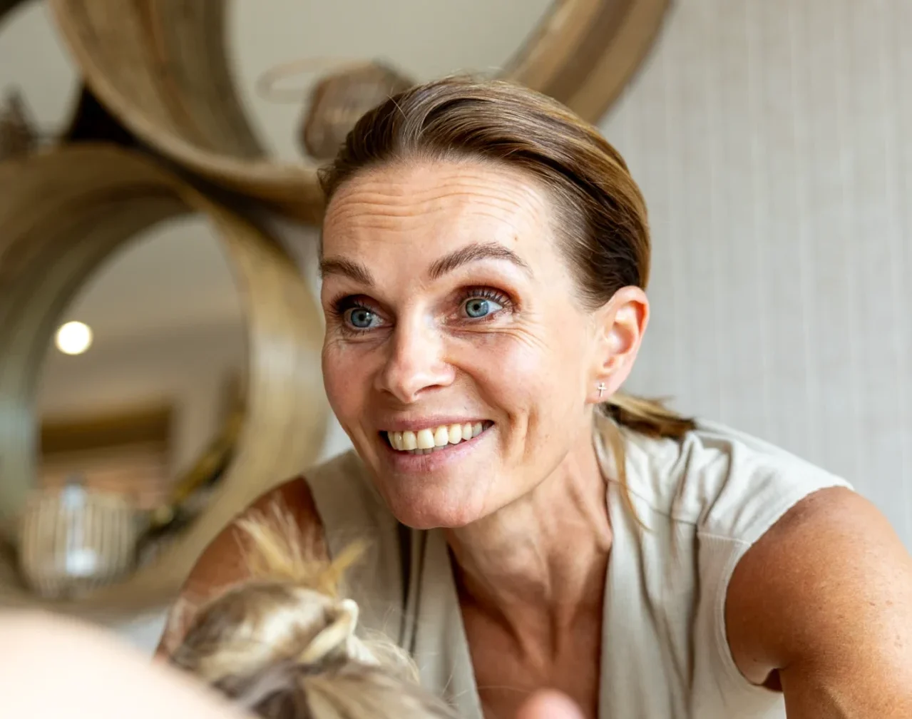 Anoek kijkt lachend naar een cliënt tijdens een behandeling